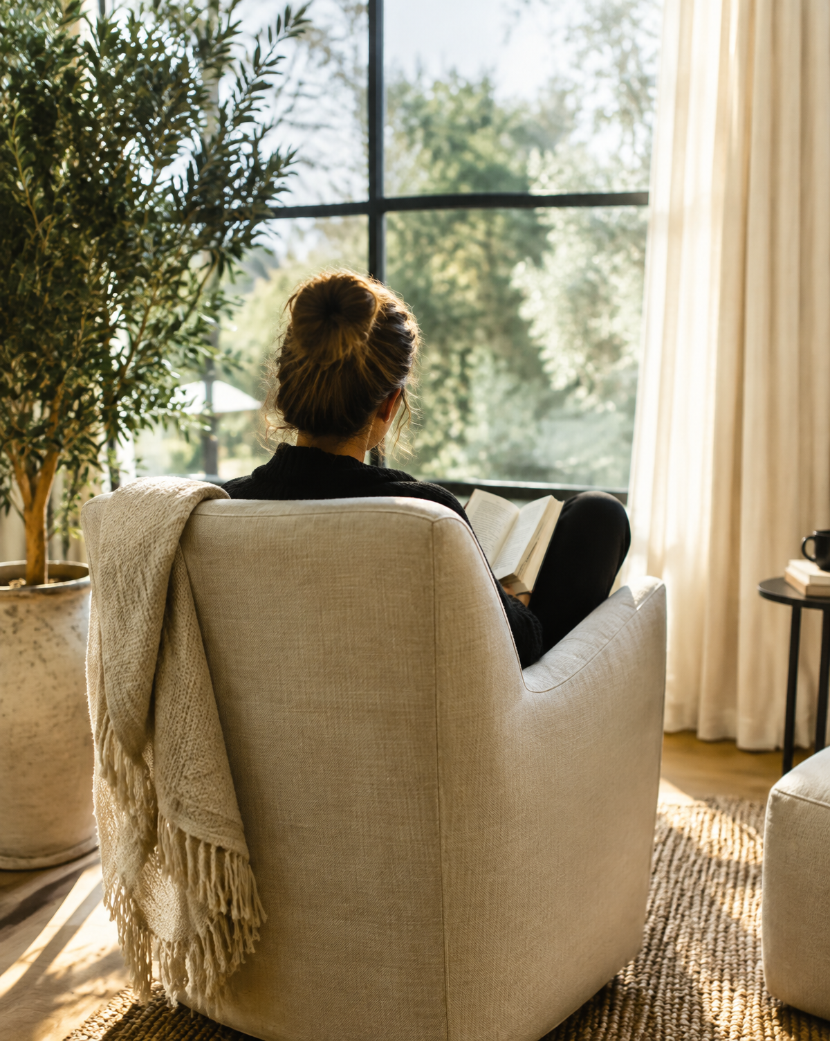 Woman reading beside a sunny window